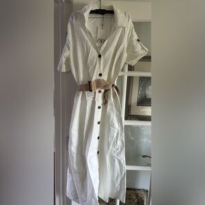 White linen dress with a tan woven belt. Never worn and tags still attached.